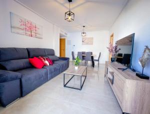 a living room with a blue couch and a table at Mar Menor Paradise by Los Pinos Holidays in San Pedro del Pinatar