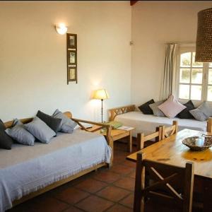 uma sala de estar com duas camas e uma mesa em DOS AGUAS em Capilla del Monte