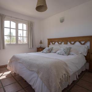 um quarto com uma grande cama branca e 2 almofadas em DOS AGUAS em Capilla del Monte