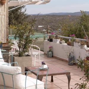 patio ze stołem i krzesłami na balkonie w obiekcie DOS AGUAS w mieście Capilla del Monte