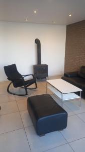 a living room with a couch and a chair and a stove at the holiday house in Klaipėda +26 photos