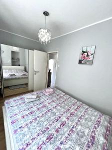 Un dormitorio con una cama grande y una lámpara de araña. en TENA, en Kukuljanovo