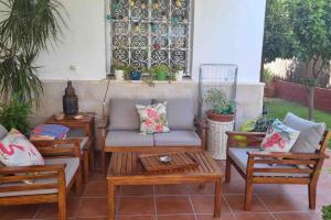 a patio with a couch and two chairs and a table at Casa Bignonia in Salteras