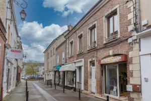 una calle vacía en un viejo pueblo con edificios en Appart luxueux hyper-centre/15mn Fontainebleau, en Montereau-Fault-Yonne