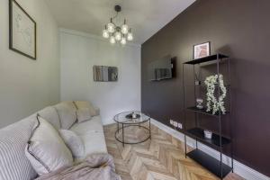 a living room with a white couch and a table at Appart luxueux hyper-centre/15mn Fontainebleau in Montereau-Fault-Yonne