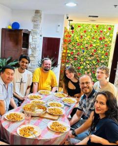 a group of people sitting around a table with food at Dreams beach hostel in Dubai