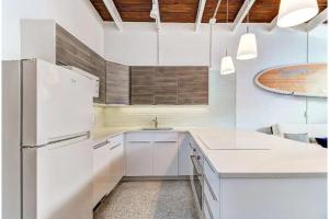 uma cozinha branca com um frigorífico e um lavatório em Beachfront Getaway in Siesta Key em Siesta Key
