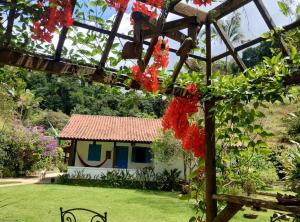 多明戈斯马丁斯Sítio Canto da Roça Com Cachoeira的花园,后方是一座小房子