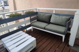 a couch sitting on a deck on a balcony at Duplex avec terrasse ombragée in Lempdes