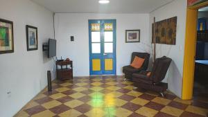 un soggiorno con una porta blu e una sedia di Hotel sol del lago a Guatapé