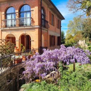a house with purple flowers in front of it at Guest House San Francesco Garden in Rapolano Terme