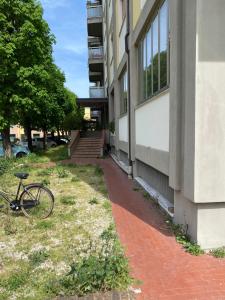 una bicicleta estacionada en el césped junto a un edificio en Gabe, en Cesena