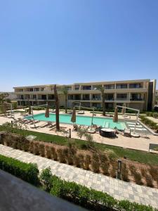 a large swimming pool with umbrellas and a building at El Gouna Pool-View Studio Rental in Hurghada