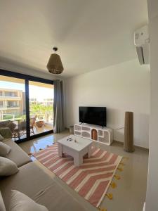 a living room with a couch and a tv at El Gouna Pool-View Studio Rental in Hurghada