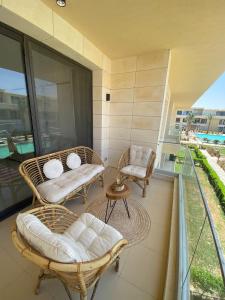 a balcony with wicker chairs and a table at El Gouna Pool-View Studio Rental in Hurghada