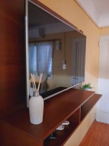 a mirror on top of a wooden shelf with a vase at Villa Lainez in Villa Mercedes