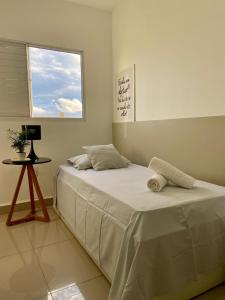 - une chambre avec un lit, une fenêtre et une table dans l'établissement Casa em condomínio fechado, à Cuiabá