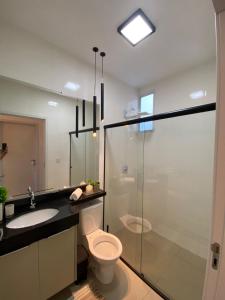 uma casa de banho com um chuveiro, um WC e um lavatório. em Casa em condomínio fechado em Cuiabá