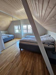 1 dormitorio con 2 camas y techo de madera en Sentrumsnær enebolig med 4 soverom, en Skien