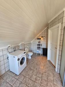 a bathroom with a washing machine and a toilet at Sentrumsnær enebolig med 4 soverom in Skien