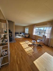 an empty living room with a chair and a table at Sentrumsnær enebolig med 4 soverom in Skien