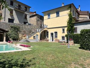 ein großes Haus mit einem Garten mit Pool in der Unterkunft Dimora Il Convento in Scrofiano