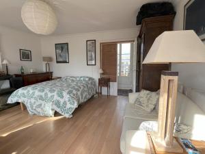 ein Schlafzimmer mit einem Bett und einem Sofa in der Unterkunft Versailles, quartier Saint Louis in Versailles