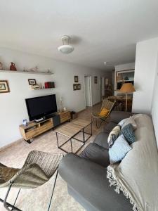 salon z kanapą i telewizorem z płaskim ekranem w obiekcie Apto Calpe con piscina. No uses coche vacaciones. w mieście Calpe