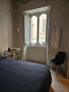 ein Schlafzimmer mit einem Bett und einem Stuhl und einem Fenster in der Unterkunft La Dimora di Corso Marconi in Fermo