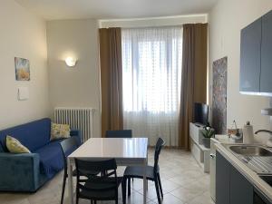 a kitchen and living room with a table and a blue couch at L'appartamentino in Montefiascone