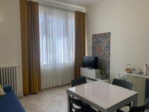 een woonkamer met een tafel en stoelen en een televisie bij L'appartamentino in Montefiascone