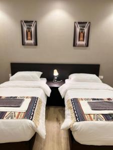 two beds sitting next to each other in a room at شقة مفروشة فاخرة جدة حي الروضة, دخول ذاتي in Jeddah