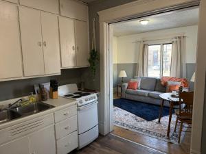a kitchen and living room with a stove and a couch at Cozy Stay Near NDSU and Downtown Fargo in Fargo