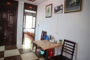 een eetkamer met een houten tafel en een geruite vloer bij May Nui Sa Pa Hostel in Sa Pa