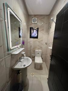 ein Badezimmer mit einem WC, einem Waschbecken und einem Spiegel in der Unterkunft شقة مفروشة فاخرة جدة حي الروضة, دخول ذاتي in Dschidda