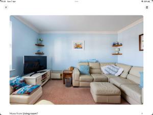 a living room with a couch and a flat screen tv at 2 bedrooms apartment with free parking in Lancing