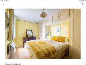 a bedroom with a large bed with a yellow blanket at 2 bedrooms apartment with free parking in Lancing