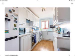 a white kitchen with white cabinets and white appliances at 2 bedrooms apartment with free parking in Lancing