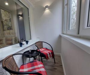 um quarto com duas cadeiras, uma mesa e uma janela em City Inn Riga Apartment, new renovated in Quiet center with balcony with parking em Riga