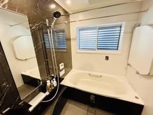 a bathroom with a shower and a sink at Accessible Four-Bedroom House near Kuzuha Station! in Hirakata