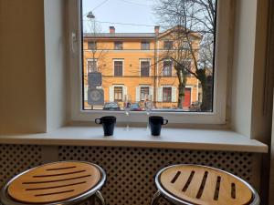two stools in front of a window with a building at City Inn Riga Apartment, new renovated in Quiet center with balcony with parking in Riga