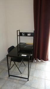 einen schwarzen Tisch und einen Stuhl in einem Zimmer in der Unterkunft VILLA POUR 21 PERSONNES 400 M2 PISCINE SALLE DE SPORT PROCHE DES PLAGES. HÉRAULT in Coulobres