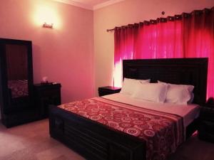 a bedroom with a large bed with pink curtains at Royal Galaxy Bed & Breakfast E-11 Islamabad - For Families Only in Islamabad