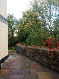 a stone retaining wall next to a brick walkway at Springhome Newport in Newport