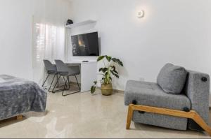 sala de estar con sofá, mesa y cama en Sababa Host-Boutique Rooms in Central Tel Aviv, en Tel Aviv
