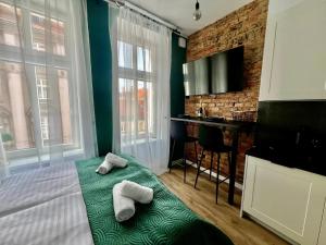 a bedroom with a bed and a desk with towels at LOFT Słowackiego in Wałbrzych