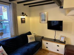 uma sala de estar com um sofá e uma televisão de ecrã plano em The Rockpool Holiday Cottage em Whitby