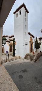 a white church with a tower on a street at Casa Medina albaycin Amazing House for 5pax in Granada