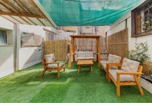 eine Terrasse mit grünem Gras und Möbeln auf einem Balkon in der Unterkunft Sababa Host-Boutique Rooms in Central Tel Aviv in Tel Aviv