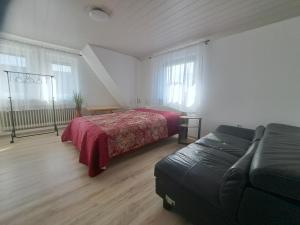 a bedroom with a bed and a couch at Am Mariental 11 in Hankensbüttel